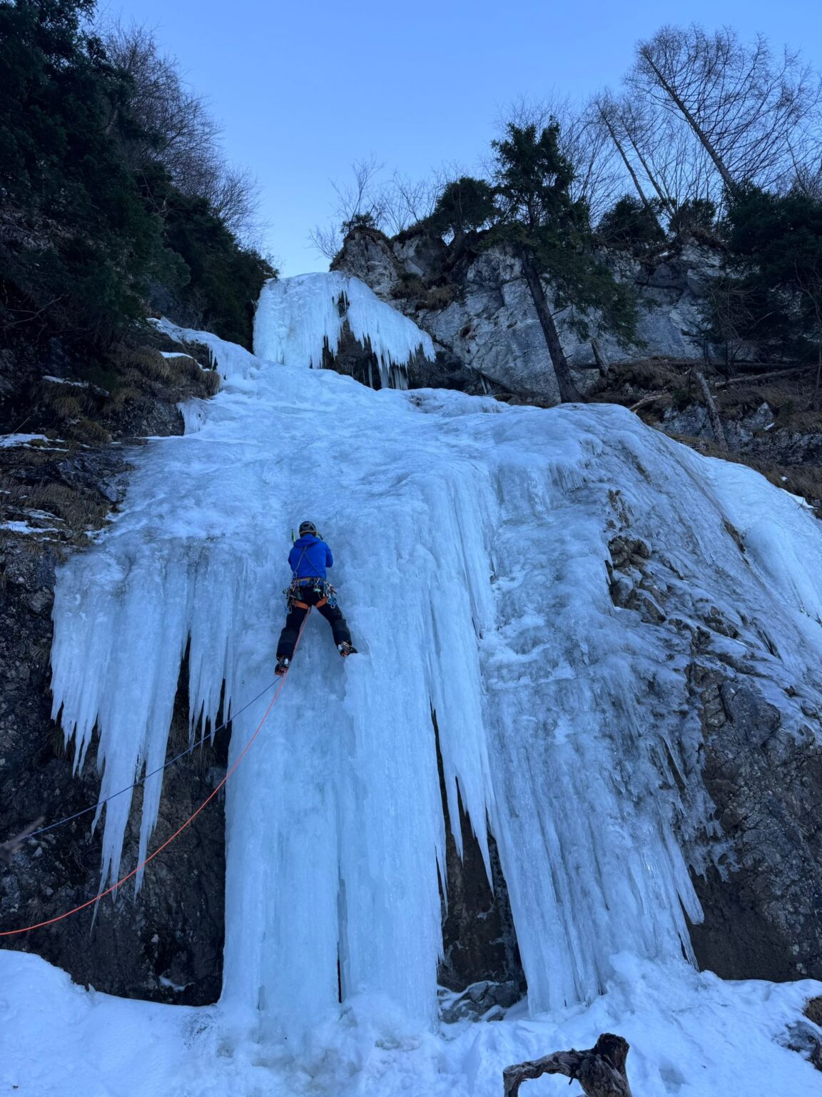 Eiskletterer an einem gefrorenen Wasserfall in Walchsee